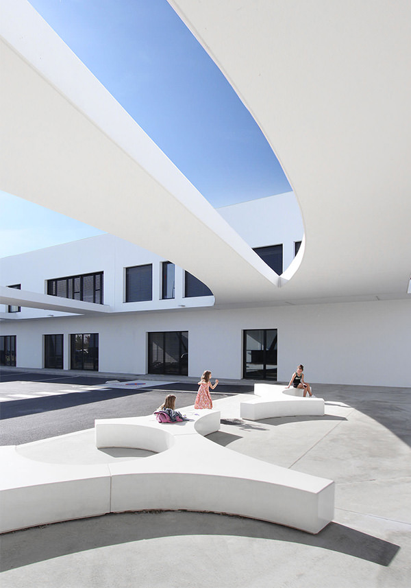 Un terrain de jeux en arabesque pour les petits blagnacais Photographie vertical de la cour côté route, des enfants jouent sur des modules au sol