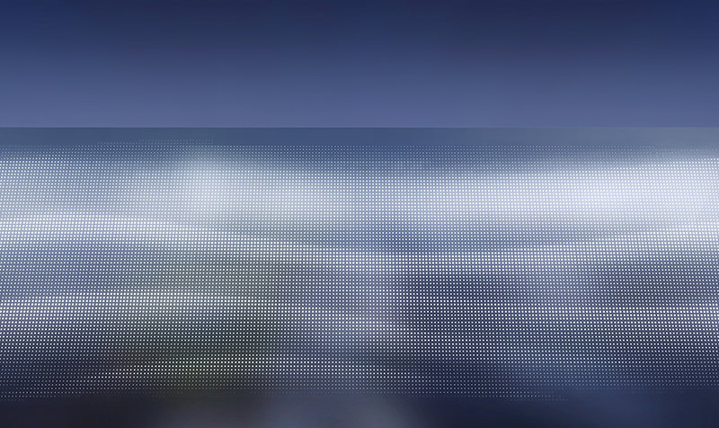 Perspective de nuit d'une facade perforée du bâtiment qui laisse passer la lumiére