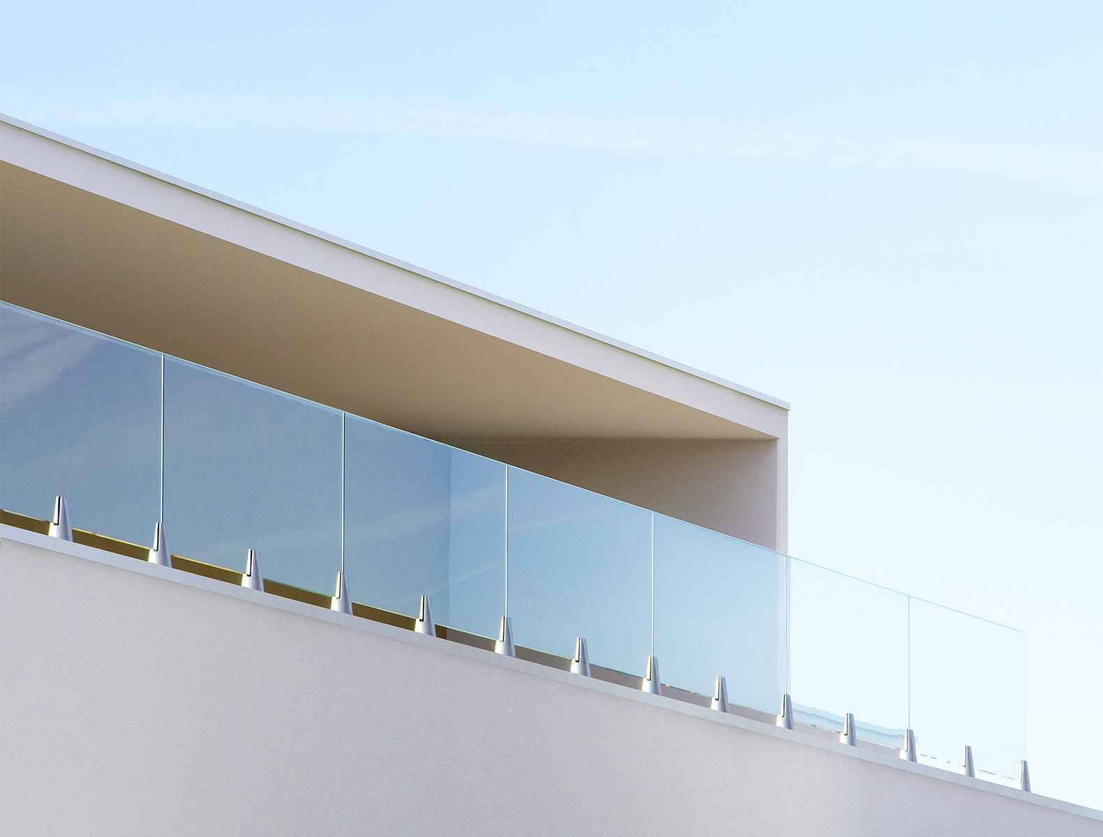 Photographie zoomé en contre plongé d'un vitrage pour terrasse et auvent béton blanc