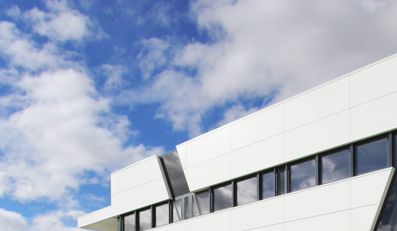 Photographie du haut de la façade noire et blanche de la CPAM du Tarn