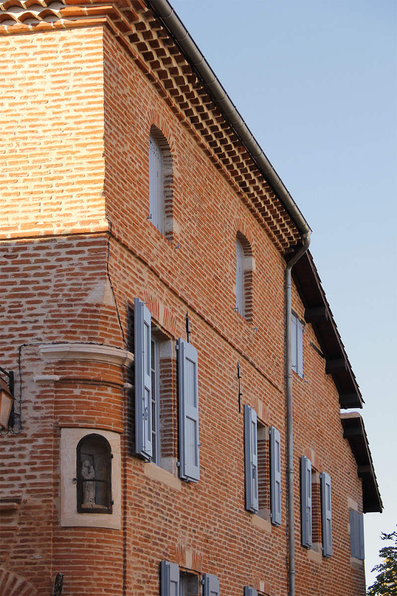 Photographie verticale du bâtiment rénové brique propre, et ciel bleu
