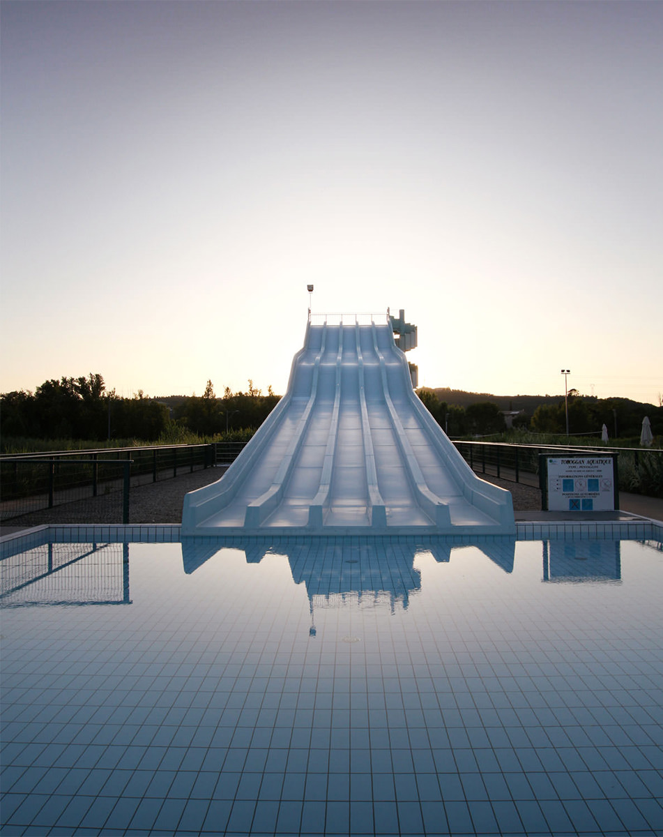 Photographie au crépuscule, face à la piscine avec les couloirs de toboggans