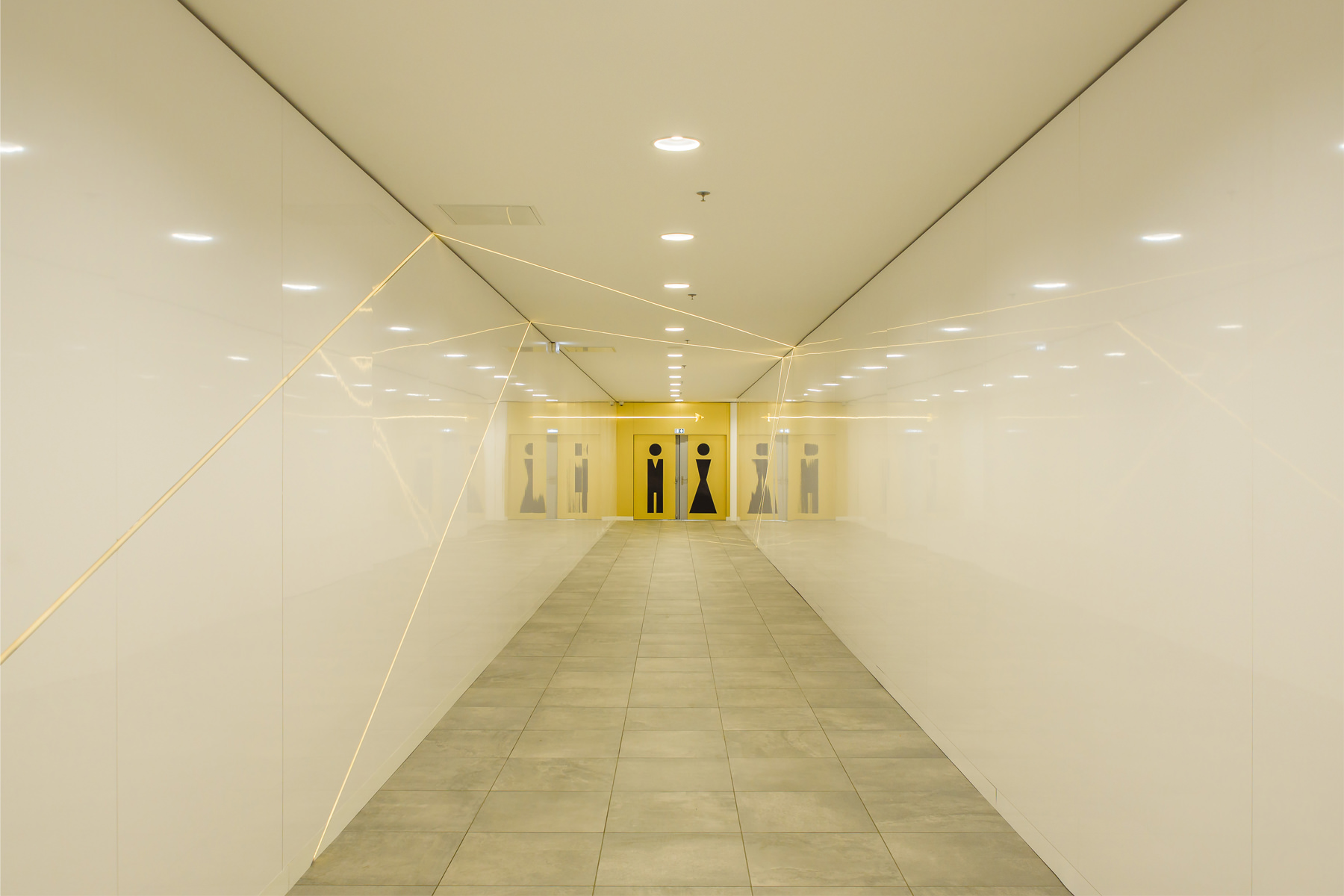 Photographie symétrique de l'entrée du couloir vers les toilettes