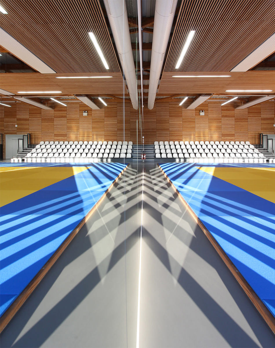 Photographie vue miroir de l'intérieur du gymnase de Buchelay, intérieur bois et tatamis bleu et jaune