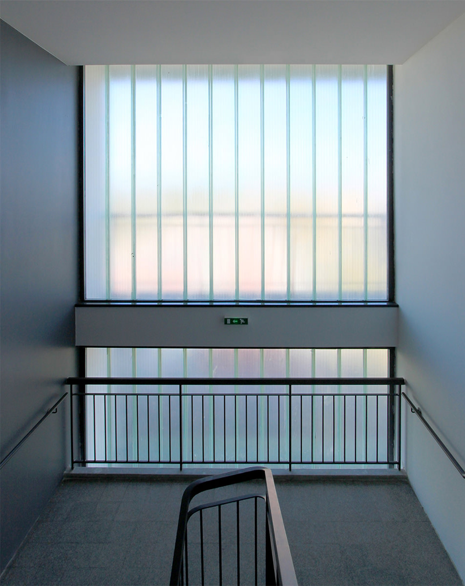 Photographie d'intérieur en face des vitrages opalescent de la colonne d'escalier