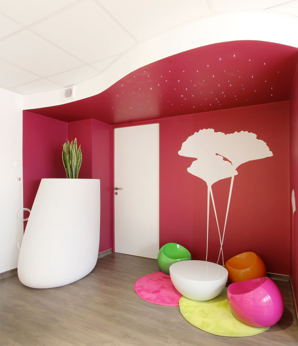 Photographie de l'espace de la porte d'entrée peint en rouge avec des motifs de fleurs blanc sur le mur