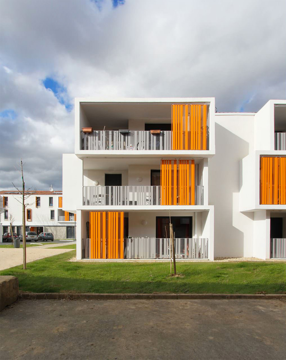 Photographie verticale en face d'un logement sur trois niveaux avec balcons