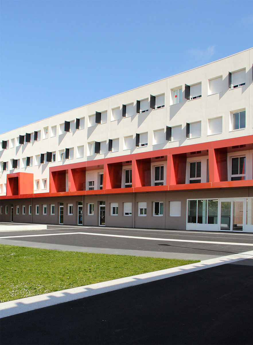 Photographie de la façade l'internat, des boîtes rouges brise-soleil sur certaines fenêtres