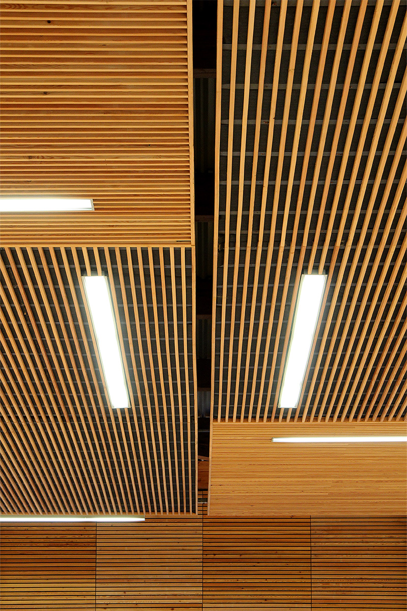 Photographie des lames bois sur le faux plafond, intégrations de tubes lumineux éclairants