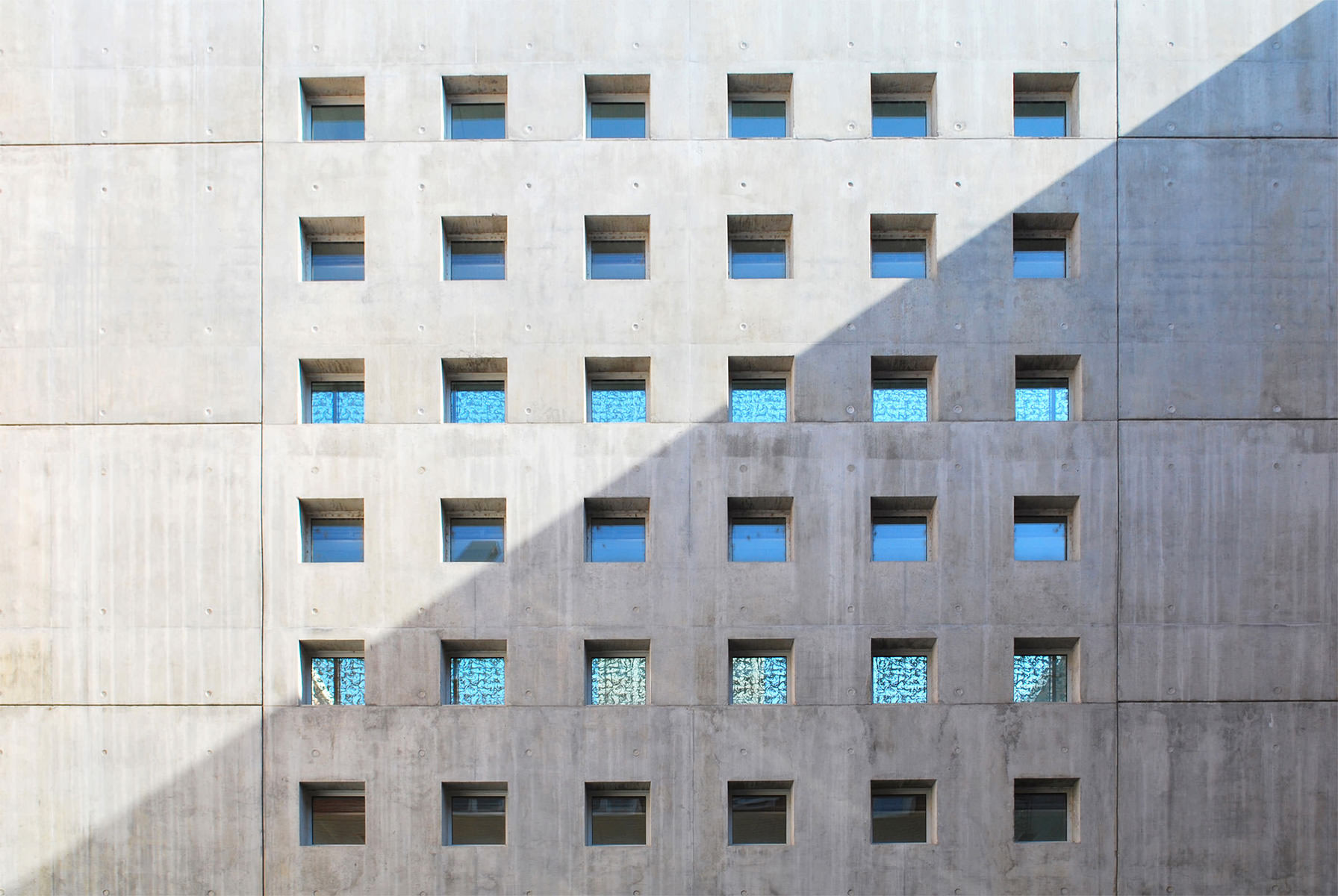Photographie d'une façade béton de l'hôpital d'Albi avec ouvertures fenêtres carrés en quadrillage