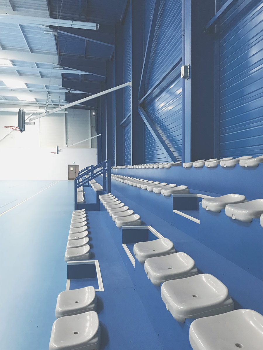 Photographie de toutes les places assises depuis les gradins bleu du gymnase