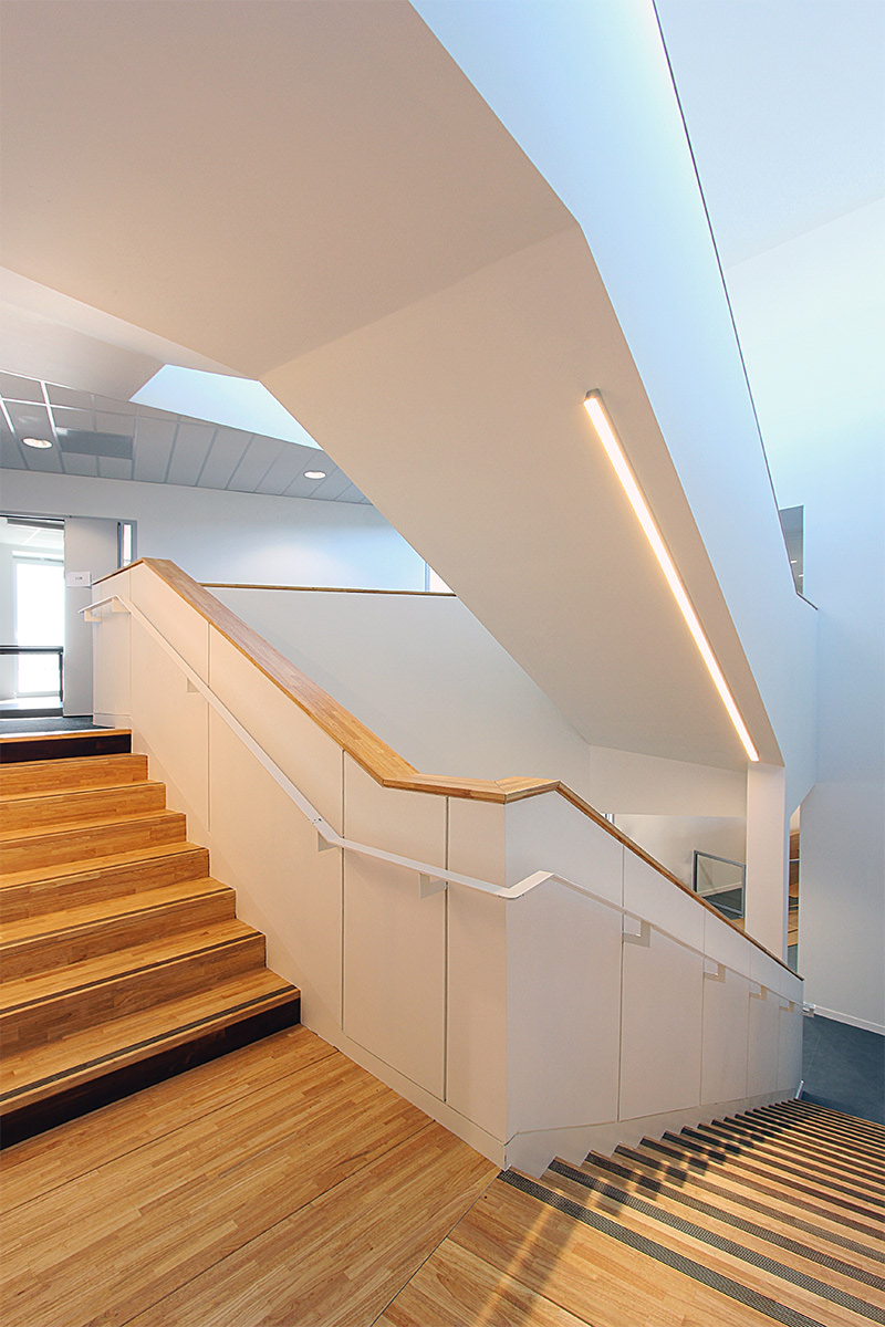 Photographie entre deux étages donnant sur l'escalier montant et descendant, bois au sol, et mur blanc, Ariane Network,