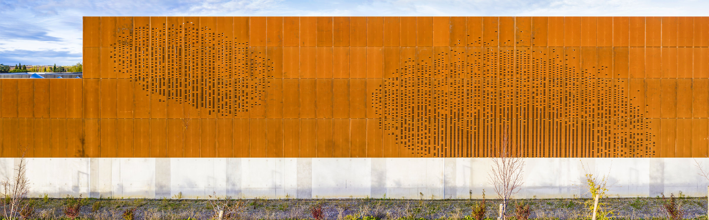 Photographie panoramique de la façade corten avec les perforations