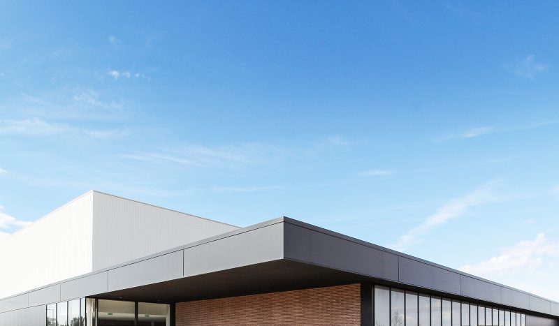 Photographie du haut du gymnase de Lescure d’Albigeois, auvent anthracite et ciel bleu