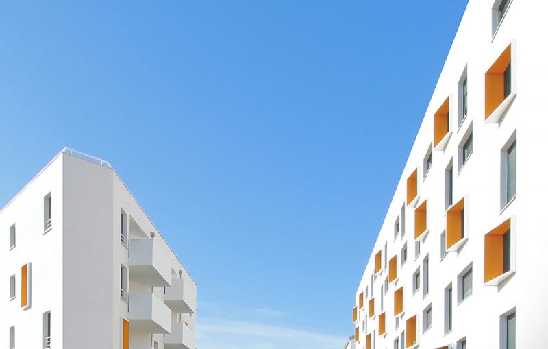 Photographie du haut des logements, bâtiment blanc et cadres de fenêtres orange