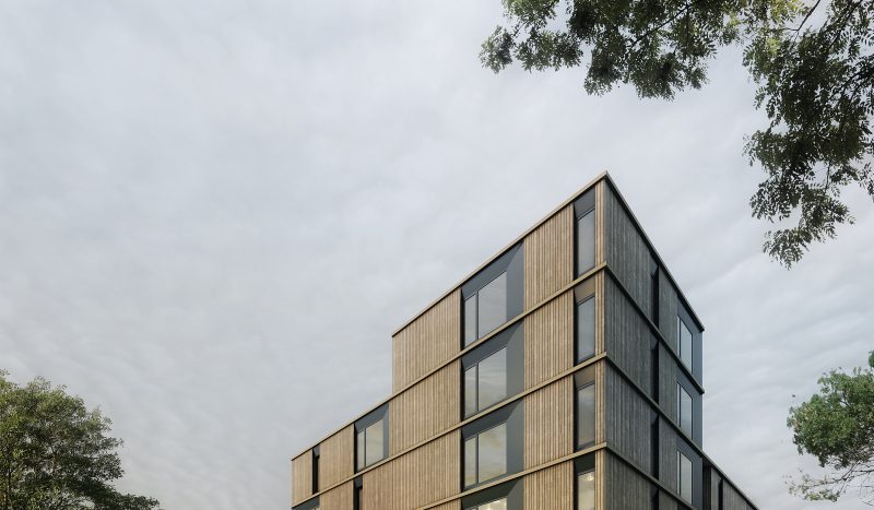 Perspectives en contre plongé d'un immeuble en préfabriqué marron clair sur fond de ciel gris