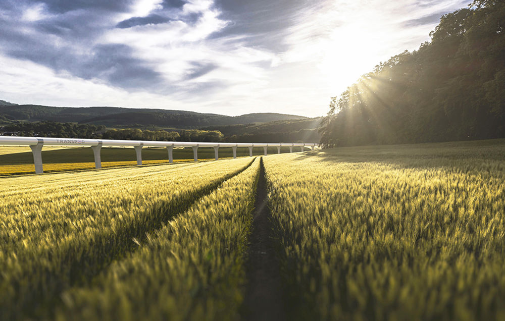 Perspective d'un tube hyperloop qui traverse un champ