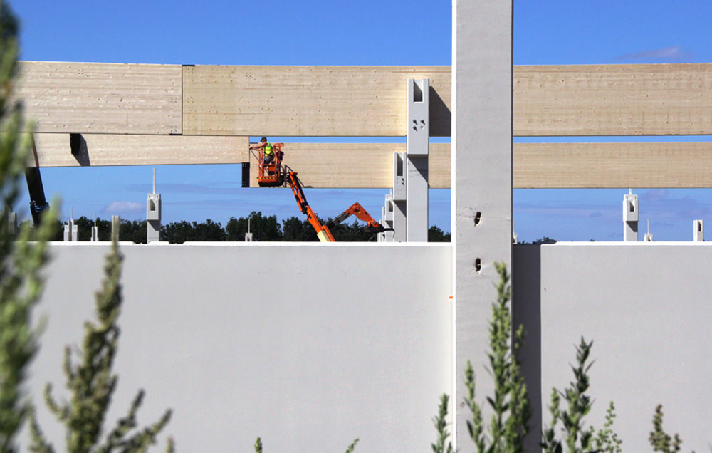 Photographie derrière des murs béton des poutres en trains d'être ériger