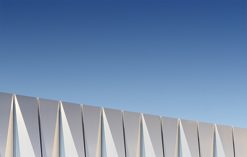 Photographie du haut du bardage du Datacenter Buisoniere reflétant le ciel bleu