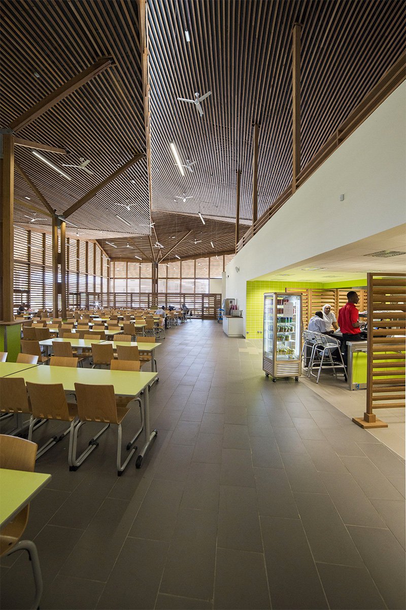 Photographie de l'intérieur du restaurant, avec les lames de bois apparentes au plafond