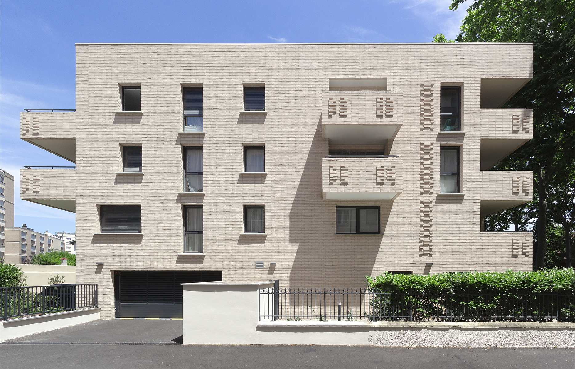 Photographie en face de la façade principale du projet Crampel, alignement des balcons et motifs de briquettes