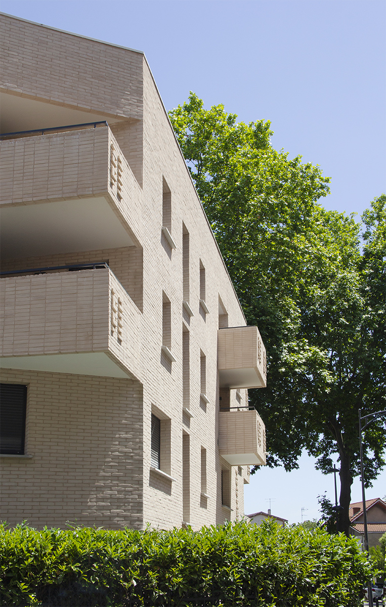 Photographie verticale de biais à la façade, sur fond de platanes verts