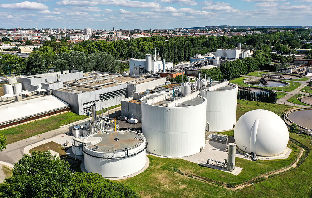 Photographie aérienne vue de drone de l'usine de méthanisation dans son contexte urbain et végétalisé