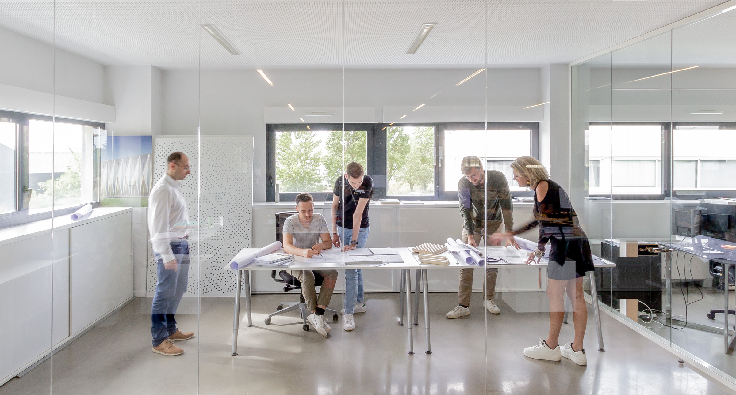 Photographie de plusieurs architectes avec Olivier et Anne pour avancer, trouver des solutions sur un projet d'architecture, salle vitrée de l'Open space à REC blagnac