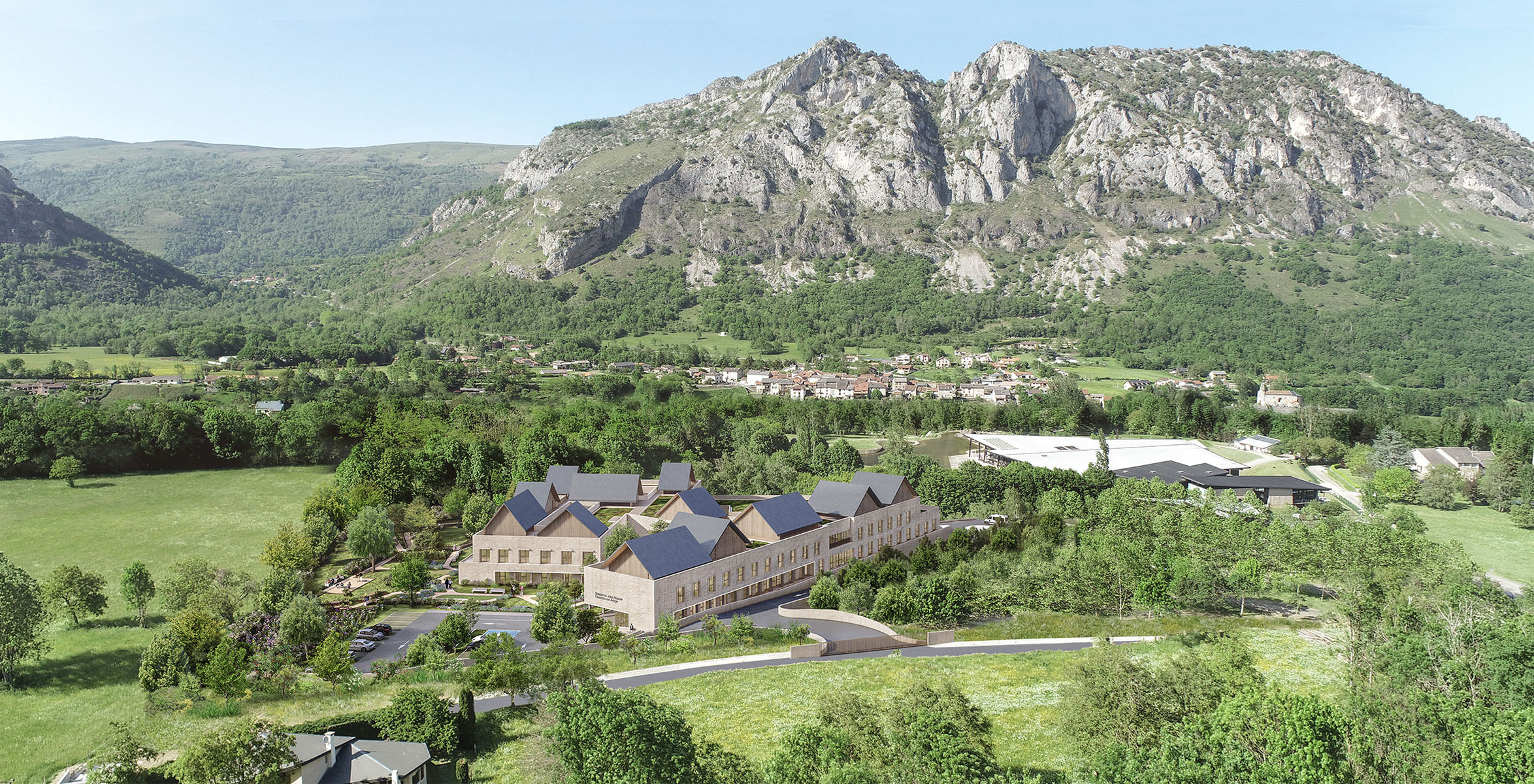 Perspective 3D aèrienne vue lointaine d'ensemble, dans toute la végétation devant le Parc de la Préhistoire on voit la teinte du béton texturé gris pierre et les toitures couleur ardoise à deux versants en enfilade, au loin les montagnes grises rocheuses