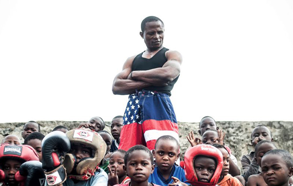 Affiche photographique du festival Sprint 2023, un coach de boxe qui regarde ses jeunes élèves