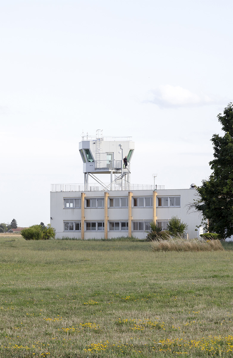 Photographie de la vigie au loin, avec sa tête qui sort d'un bâtiment