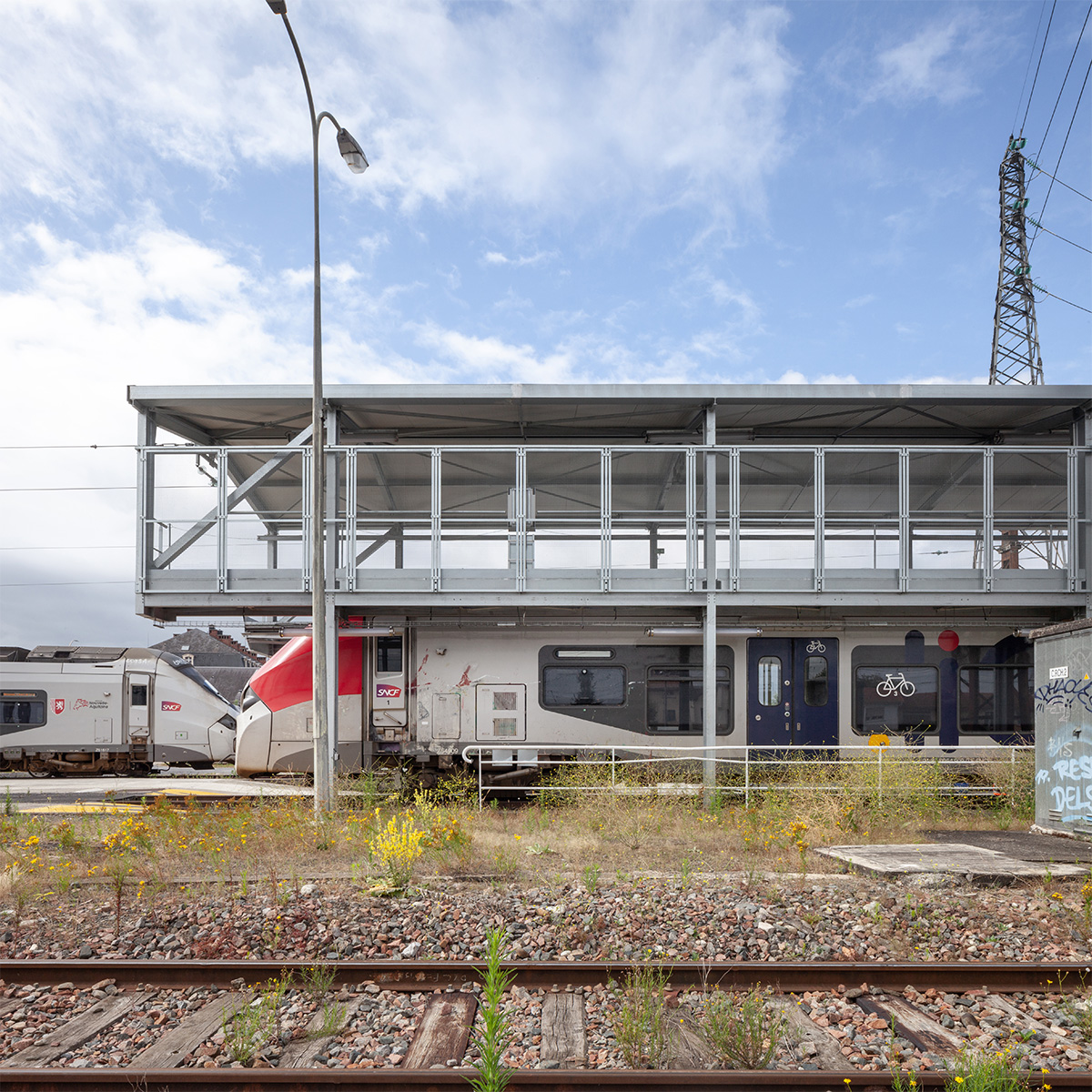 Photographie face à la longueur de la structure depuis l'espace des rails extèrieurs, un train est en maintenance