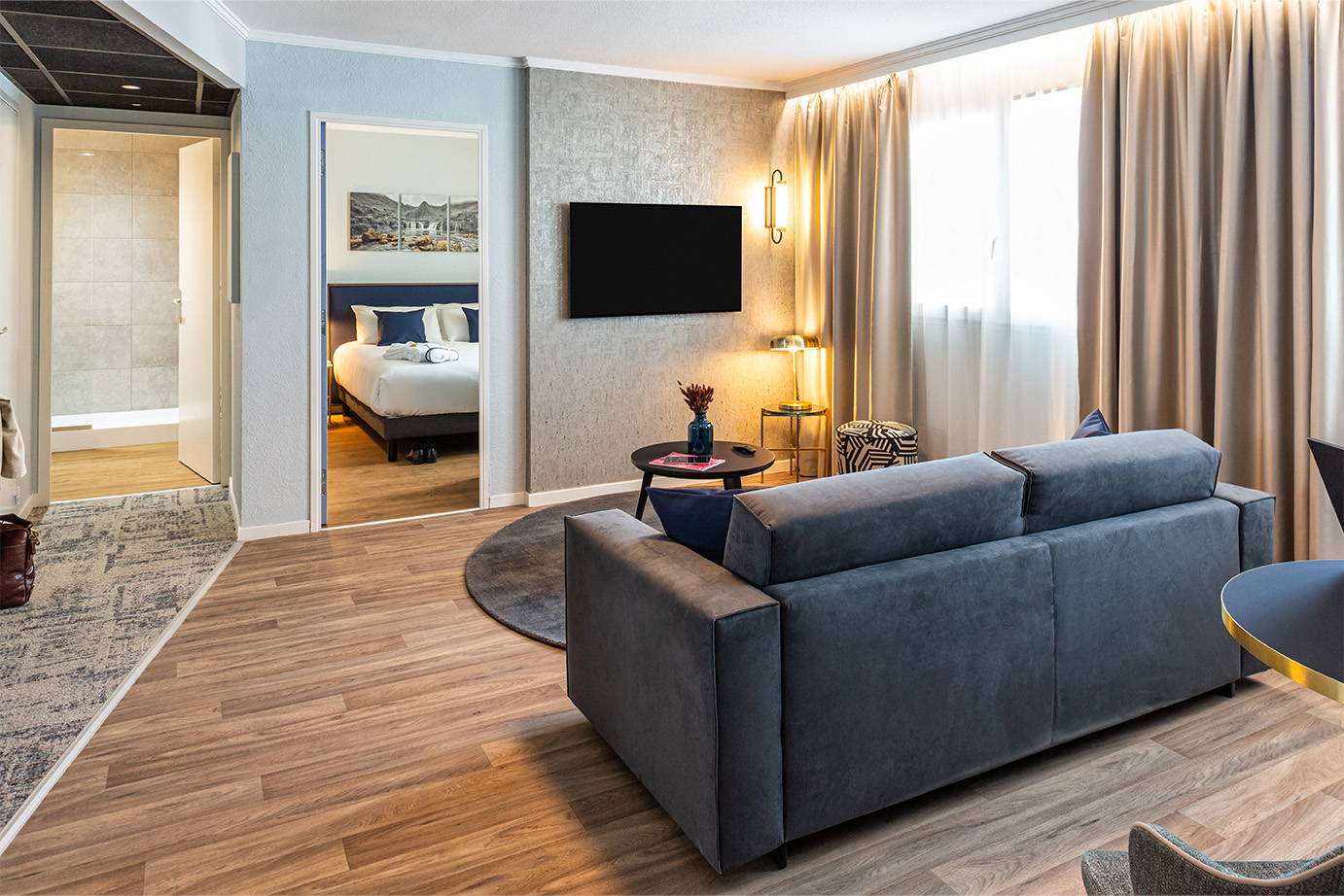 Photographie d'un appartement lumineux avec sol en bois, mur clairs et mobiliers bien assortis